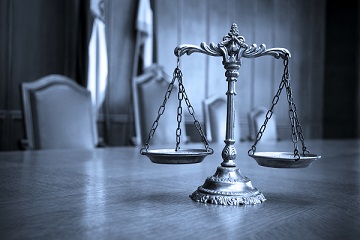 Scales of justice sitting on table in empty conference room befor person incriminates themselves by Speaking With Police