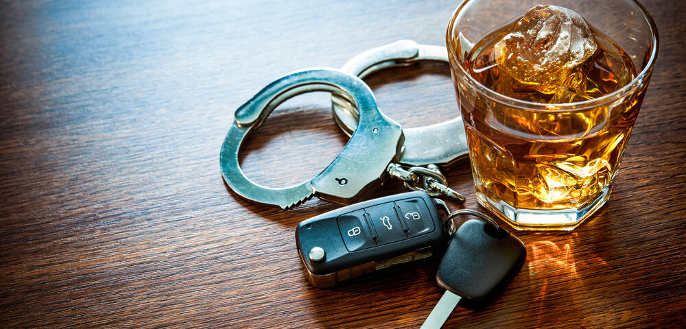 5 Tips For Avoiding OWI Drivers - Whiskey with car keys and handcuffs concept for drinking and driving