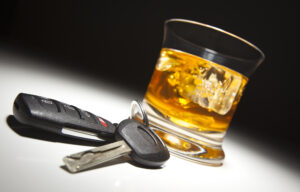 DUI defense attorney with a glass of whiskey and car keys under dramatic lighting on a table